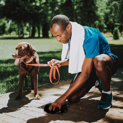 Young African Man Cleaning Up After Dog.